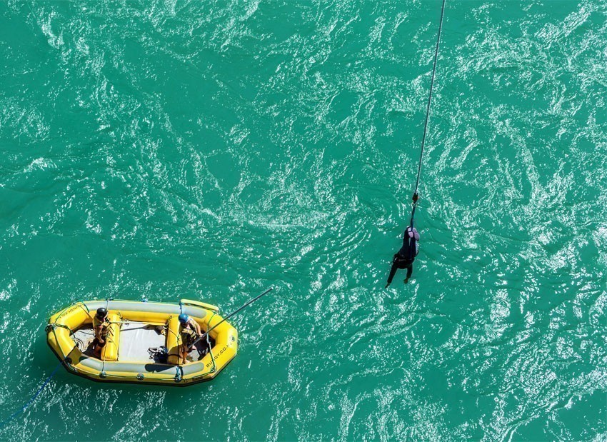 AJ Bungy's crew on rubber boat use long stick to grab their customer after bungy jump from the Kawarau Bridge in Queenstown | 7 Awesome Things to Do in New Zealand
